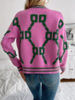 Close-up showing the geometric pattern and knitted construction of the cardigan.